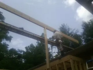 Carpenter setting a ridge beam over a new addition frame — Ice Dam Removal by Roofing Brothers in Elvaston