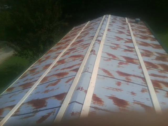 Rusted metal roof panels with new wood purlins before replacement — Storm Damage Roof Repair in Elvaston by Roofing Brothers
