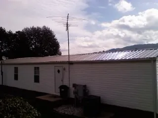 New metal roof on a single wide mobile home with a TV antenna in Elvaston