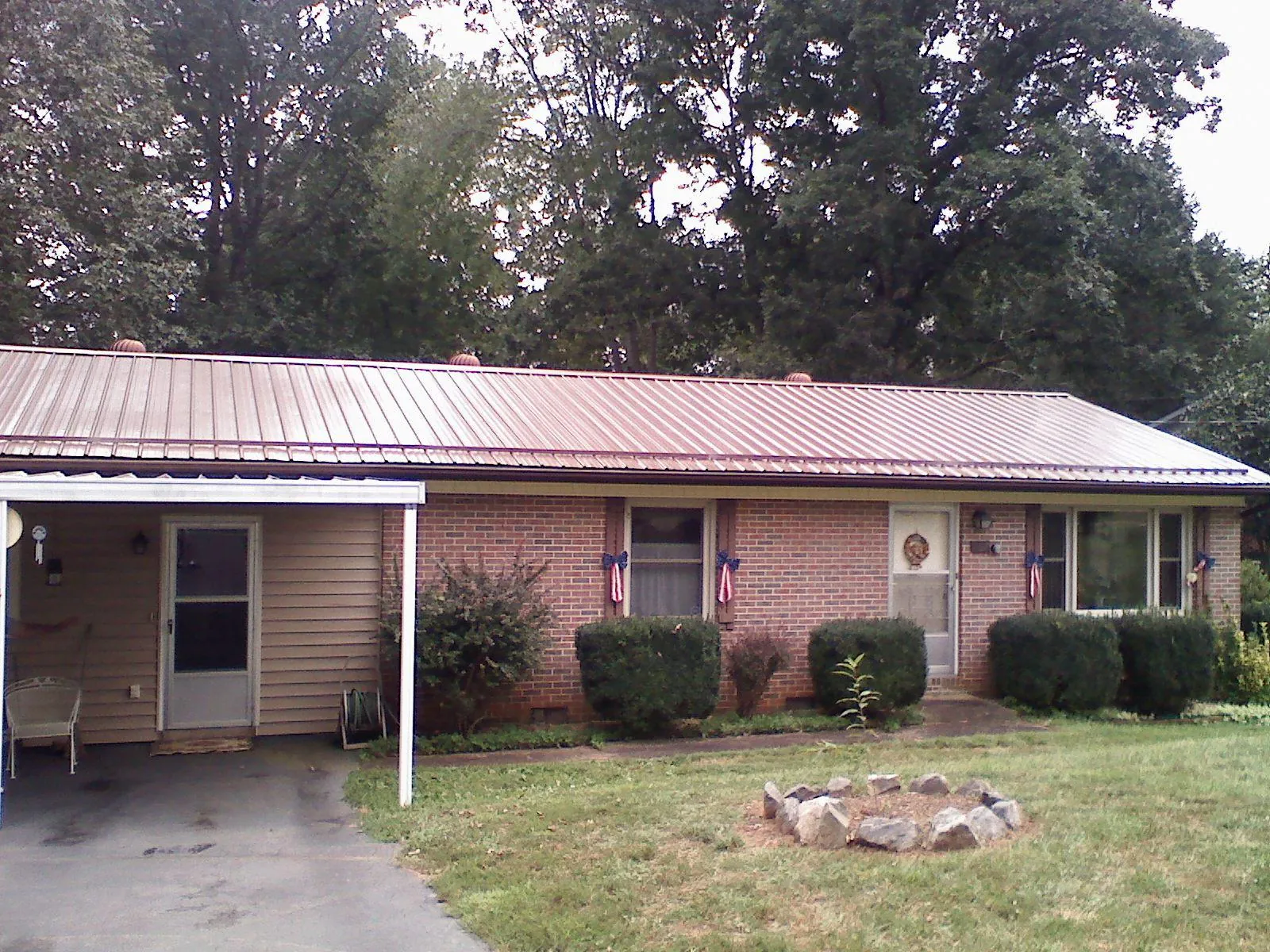 Bronze metal roof and carport on a brick ranch home — Roof Repair work by our crew in Elvaston